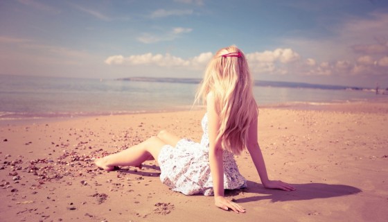 girl sitting at beach sum…